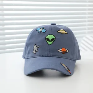 Detail of space-themed embroidery with alien and UFO patches on a cotton baseball cap