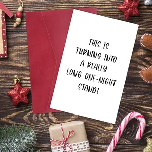 Funny Christmas greeting card with humor text and red envelope on wooden background