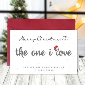 Funny Christmas card with envelope on wooden table with blurred tree background