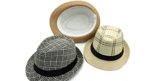 Dettaglio di cappelli fedora in paglia intrecciata con motivi diversi e fascia antisudore