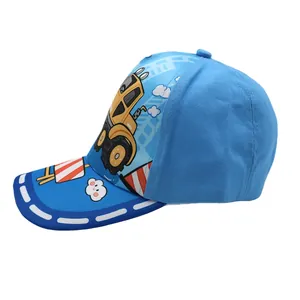 Detail of blue kids baseball cap featuring a yellow cartoon excavator print and sun visor