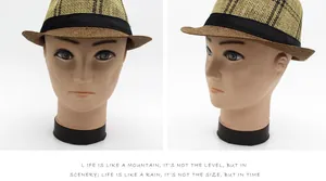 Dettaglio di un cappello fedora in paglia bicolore con un nastro decorativo nero