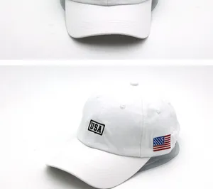 Detail of USA embroidery and flag patch on white cotton sports baseball cap