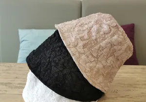 Detailed view of bucket hats in black, white and beige with textured crinkle fabric