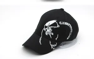Detailed close-up of white gothic skull embroidery on a black cotton baseball cap