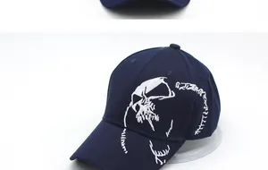 Detail of white skull embroidery on navy twill baseball cap with a street style look