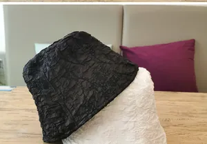 Detail shot of black and white bubble texture bucket hats on a wooden surface