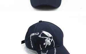 Detail of navy blue cotton baseball cap with intricate white skull embroidery on white background