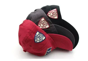Close-up of BROOKLYN baseball caps in burgundy, grey and black with detailed NY embroidery