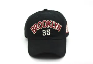 Close-up of Brooklyn 35 embroidery and shield patch on black cotton baseball cap
