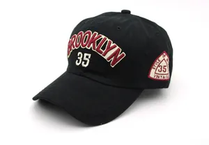 Close-up of vintage Brooklyn embroidery and side patch on black cotton baseball cap