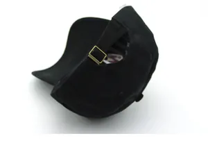 Detail of black cotton baseball cap with adjustable bronze metal buckle and washing label