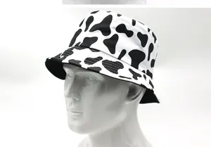 Dettaglio di un cappello da sole double-face con un audace motivo a mucca bianco e nero