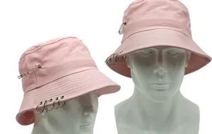 Detailansicht eines rosa Fischerhuts aus Baumwolle mit dekorativen Metallringen und Nadeln