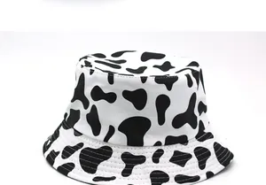 Dettaglio del cappello a secchiello reversibile con stampa mucca in bianco e nero e cuciture