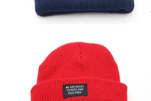 Detail of ribbed knit beanie with motivational slogan patch in navy and red colors