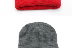 Close-up of ribbed knit texture on red and dark grey winter beanie hats with detail