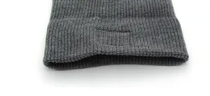 Close-up of dark grey knitted hat fabric with a focus on ribbing texture and elastic weave