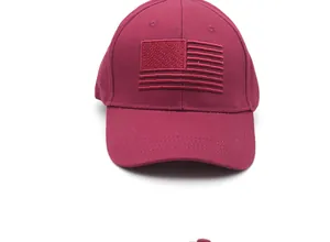 Close-up of the USA flag embroidery detail on a wine red cotton baseball cap