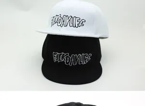 Detail of 3D letter embroidery on two snapback hats in black and white colors