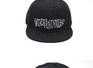 Close-up of black flat brim baseball cap featuring white FUCKDAYLIFE graffiti embroidery