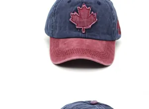 Detail of embroidered red maple leaf on washed cotton baseball cap with vintage distressed edges