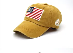 Dettaglio del ricamo USA e della toppa bandiera americana sul cappellino giallo senape