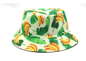 Détail d'un chapeau bob en coton blanc avec imprimé banane jaune et feuilles vertes