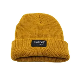 Ginger yellow ribbed knit beanie with a stylish black graphic patch for winter warmth