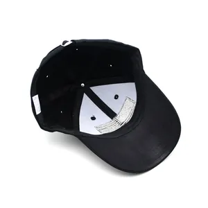 Internal structure of black cotton baseball cap showing seams and 100% cotton label