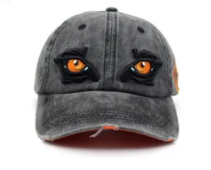 Close-up of eagle eye embroidery and distressed brim details on a washed cotton baseball cap
