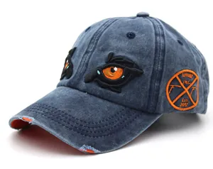 Macro detail of washed blue cotton baseball cap with orange embroidery and distressed brim