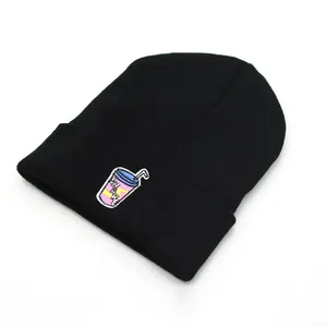 Close-up of black knit beanie featuring a colorful shake drink embroidery detail
