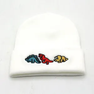 White knitted beanie with colorful cartoon dinosaur embroidery for winter warmth