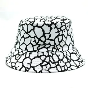 Close-up detail of white bucket hat with black giraffe print pattern and cotton texture
