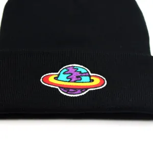 Black knit beanie with earth embroidery featuring a colorful planet patch and red ring