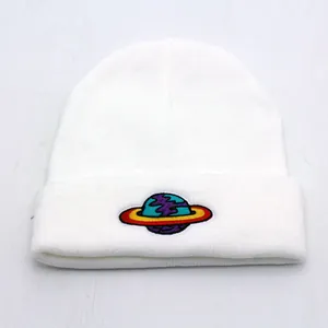White ribbed knit beanie hat featuring a colorful earth planet embroidery on the cuff