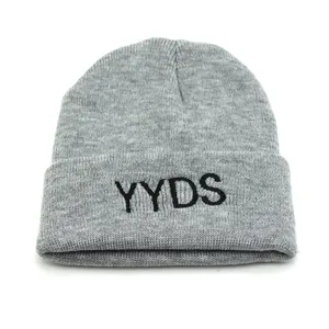 Primer plano del gorro de punto gris claro con bordado YYDS negro y textura de canalé