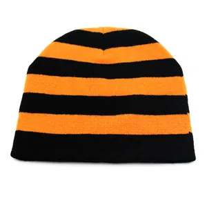 Nahaufnahme der dicken Strickstruktur der orange-schwarz gestreiften Beanie-Mütze