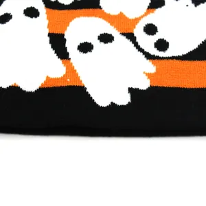 Nahaufnahme der Stricktextur mit orangen Streifen und Gespenstermustern für Halloween