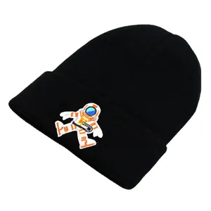 Black ribbed knit beanie featuring detailed astronaut embroidery on a fold-over cuff