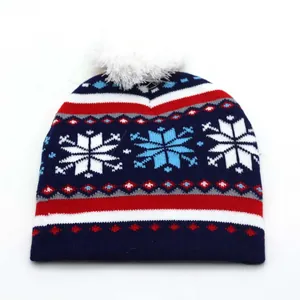 Detail of knitted Christmas hat featuring festive snowflake patterns and a soft white pompom