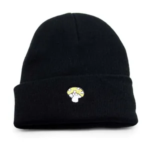 Détail de la broderie champignon sur un bonnet noir en tricot pour homme et femme