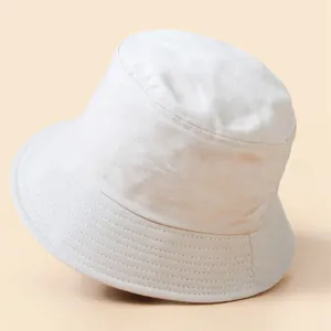 Close-up of beige cotton twill bucket hat showing detailed stitching on the brim