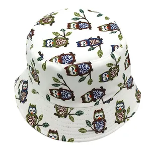 Reversible bucket hat with cute cartoon owl print and green leaf pattern on white cotton fabric