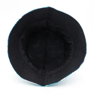 Reversible bucket hat featuring creative blue and green leaf patterns with black inner lining