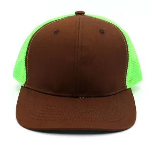 Detail view of a two-tone flat brim trucker hat with brown front and neon green mesh backing