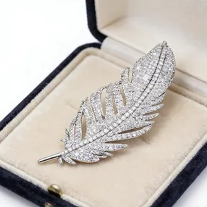 Exquisite silver feather brooch with pavé zircon stones in a navy blue jewelry box