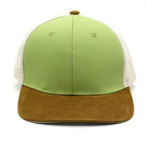 Detail view of a color-block trucker hat featuring green canvas and white mesh panels