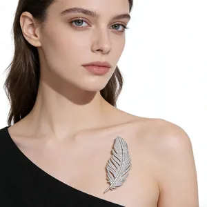 Macro shot of silver feather brooch featuring shimmering white zircons on a model